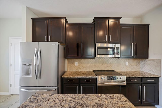 kitchen featuring dark brown cabinetry, light stone countertops, and stainless steel appliances