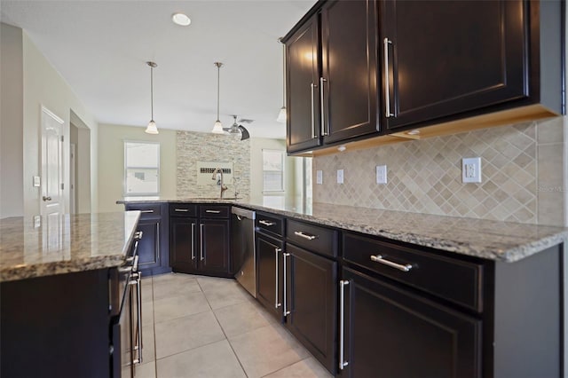 kitchen featuring light stone countertops, stainless steel dishwasher, sink, pendant lighting, and light tile patterned floors