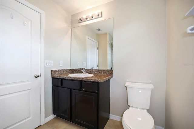 bathroom with tile patterned flooring, vanity, and toilet