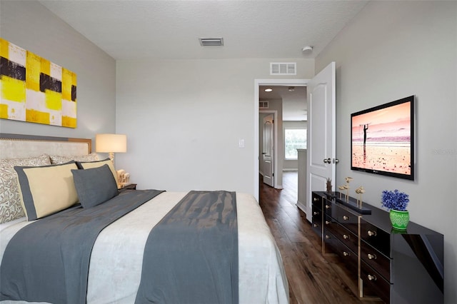 bedroom featuring dark wood-type flooring and a textured ceiling