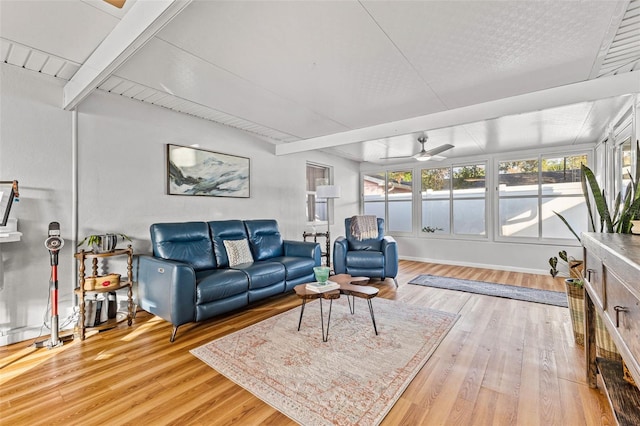 living room with beamed ceiling, hardwood / wood-style floors, and ceiling fan