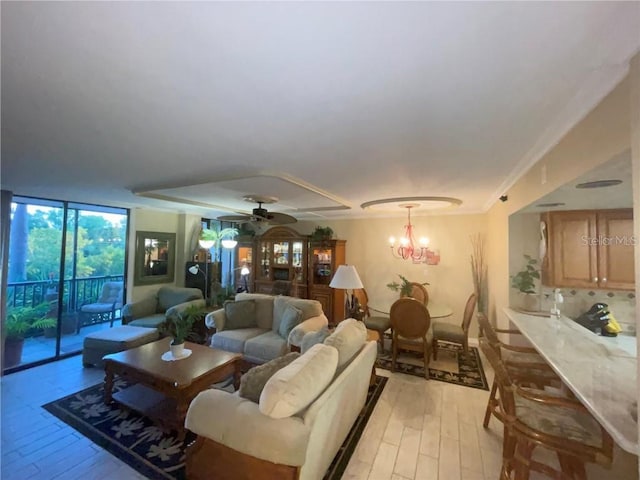 living room featuring floor to ceiling windows, light hardwood / wood-style flooring, and ceiling fan with notable chandelier