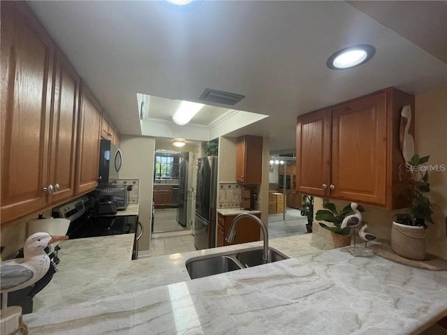 kitchen featuring sink, stainless steel appliances, tasteful backsplash, kitchen peninsula, and crown molding