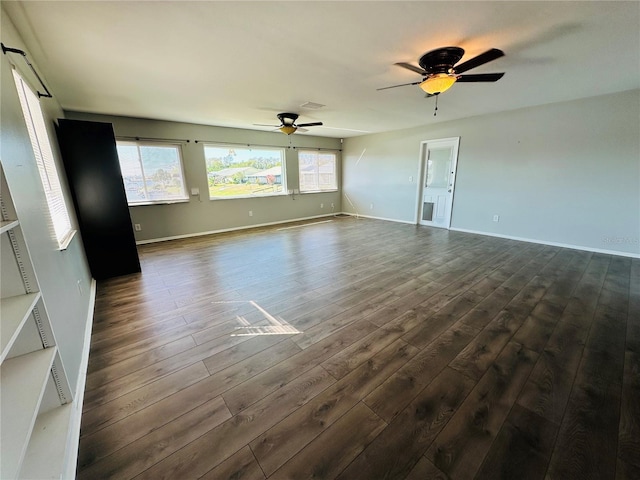 unfurnished living room with dark wood-type flooring and ceiling fan