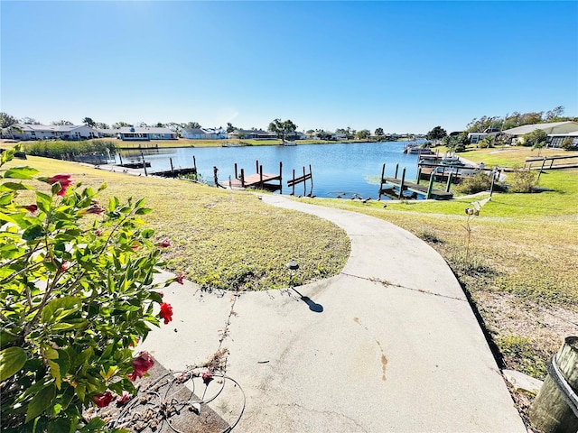 view of dock featuring a water view and a yard