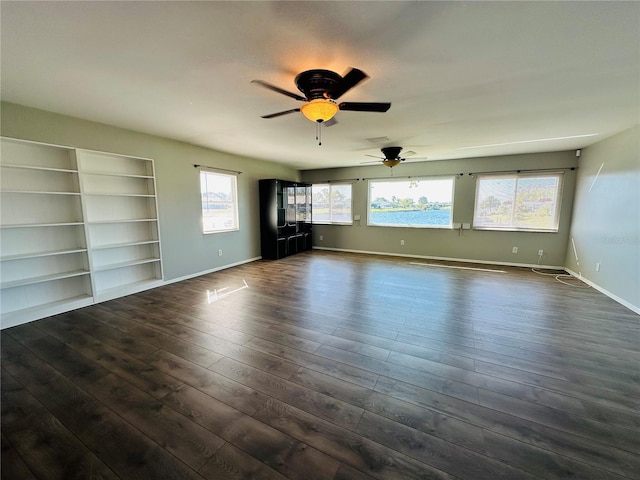 unfurnished living room featuring dark wood-type flooring and ceiling fan