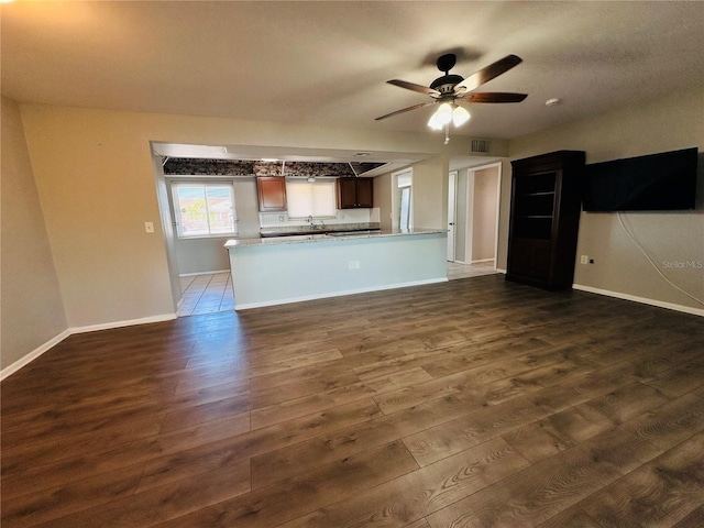 unfurnished living room with dark wood-type flooring and ceiling fan