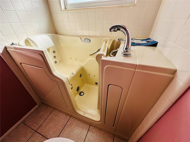 bathroom featuring tile patterned flooring and a bath