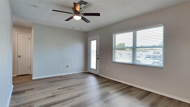 unfurnished room with ceiling fan, light hardwood / wood-style floors, and a textured ceiling