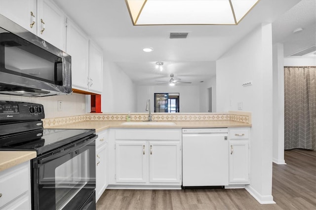 kitchen featuring dishwasher, white cabinets, black / electric stove, and sink