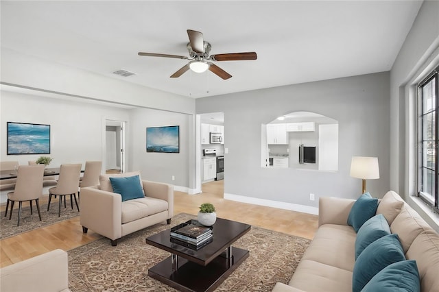 living room featuring ceiling fan and hardwood / wood-style flooring