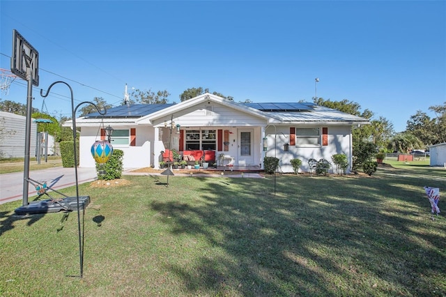 view of front of house with a porch, a front yard, and solar panels