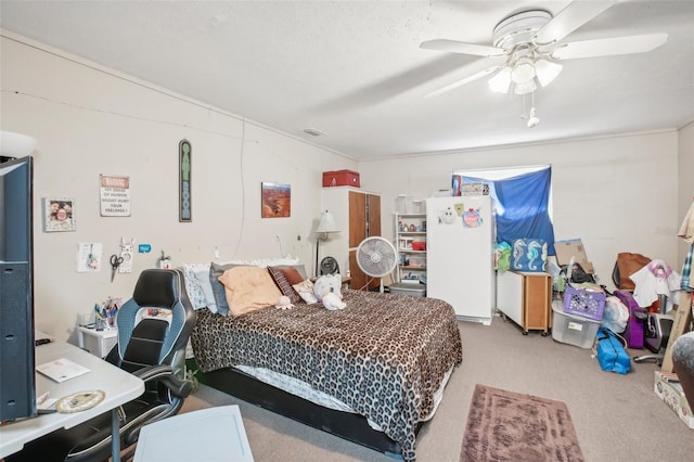 carpeted bedroom featuring a textured ceiling, white refrigerator, and ceiling fan