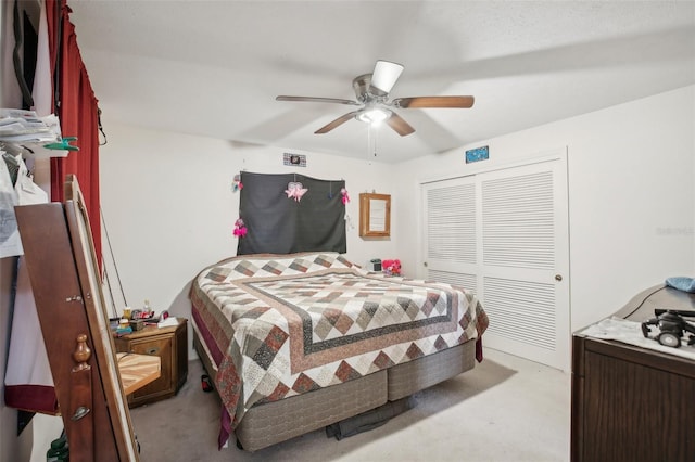 carpeted bedroom featuring ceiling fan and a closet