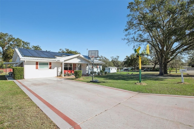 view of front of property with solar panels and a front lawn