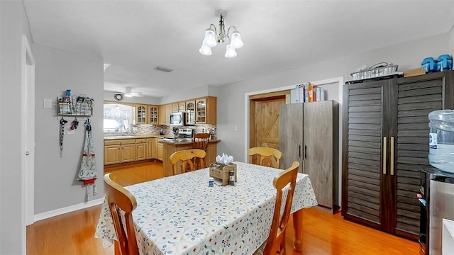 38919 3rd Ave, Zephyrhills, FL 33542 - dining area with light wood finished floors and a chandelier