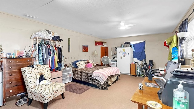 38919 3rd Ave, Zephyrhills, FL 33542 - bedroom featuring freestanding refrigerator, carpet flooring, and a ceiling fan