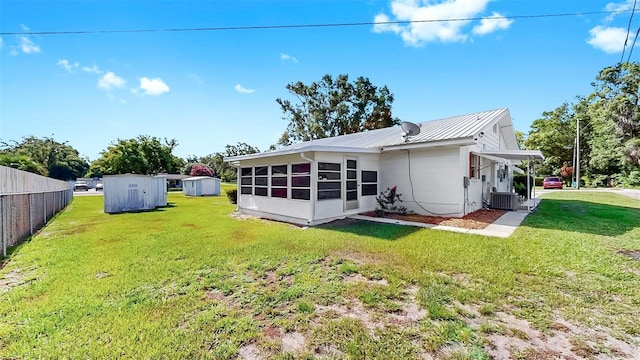 38919 3rd Ave, Zephyrhills, FL 33542 - rear view of house with a storage unit and a metal roof