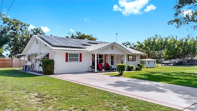 38919 3rd Ave, Zephyrhills, FL 33542 - view of front of house featuring a porch, roof mounted solar panels, and a metal roof