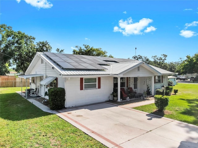 38919 3rd Ave, Zephyrhills, FL 33542 - view of front facade with covered porch, roof mounted solar panels, a metal roof, and concrete block siding