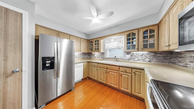 38919 3rd Ave, Zephyrhills, FL 33542 - kitchen featuring stainless steel appliances, a ceiling fan, light wood-style floors, tasteful backsplash, and light countertops