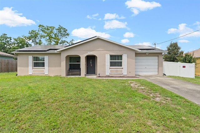 ranch-style house with solar panels, a garage, and a front lawn