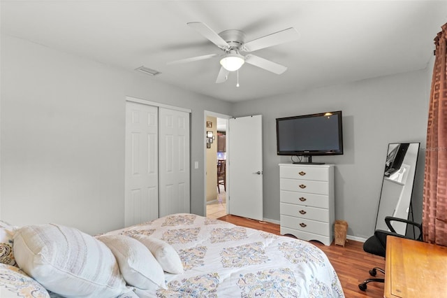 bedroom featuring ceiling fan, a closet, and light hardwood / wood-style floors