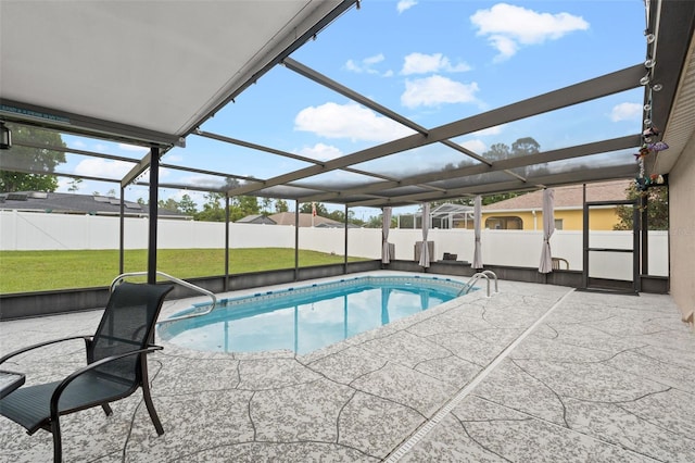 view of pool with glass enclosure, a patio area, and a yard