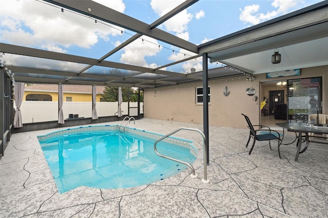 view of swimming pool featuring glass enclosure and a patio area