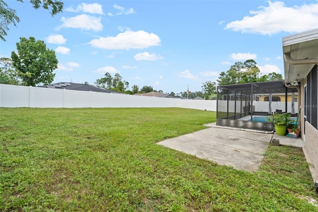 view of yard featuring a patio, glass enclosure, and a sunroom