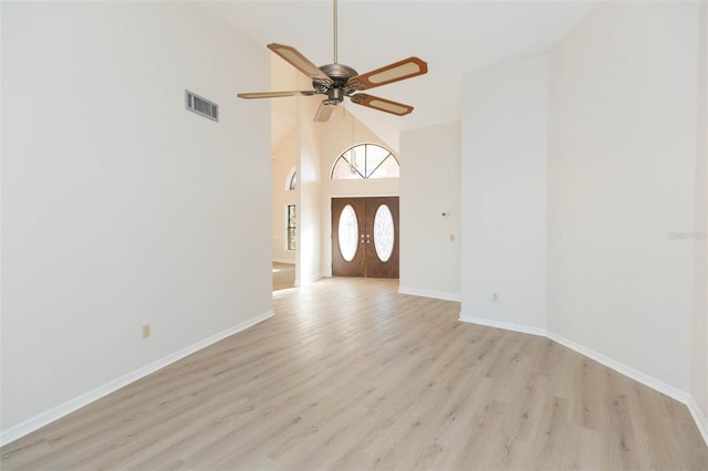 foyer entrance with french doors, light hardwood / wood-style floors, high vaulted ceiling, and ceiling fan