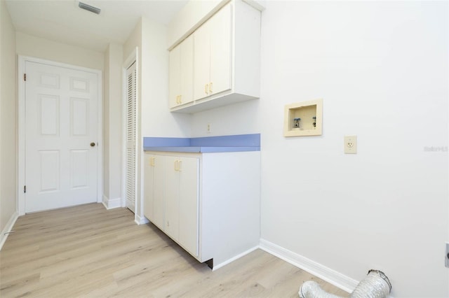 washroom with cabinets, hookup for a washing machine, and light hardwood / wood-style floors