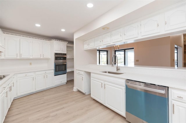 kitchen featuring sink, white cabinets, stainless steel appliances, and light wood-type flooring