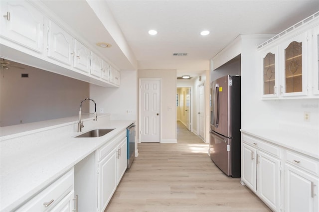 kitchen with light hardwood / wood-style floors, sink, white cabinetry, and stainless steel appliances