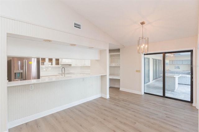 kitchen with pendant lighting, white cabinetry, light wood-type flooring, and stainless steel fridge with ice dispenser