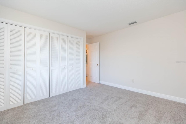 unfurnished bedroom featuring carpet and a closet