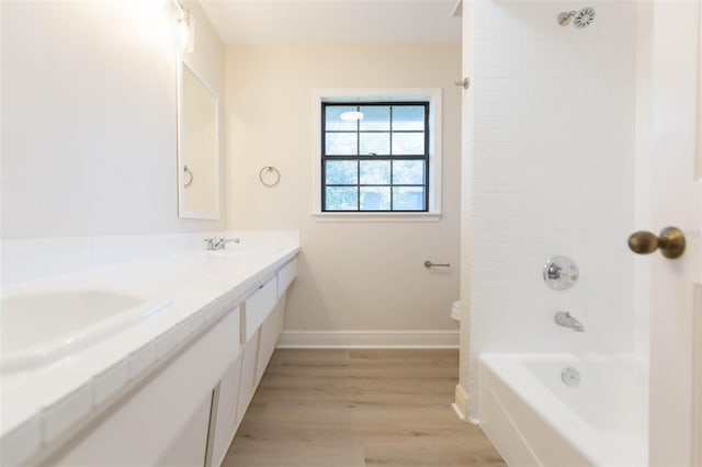 full bathroom with toilet, vanity, wood-type flooring, and tiled shower / bath