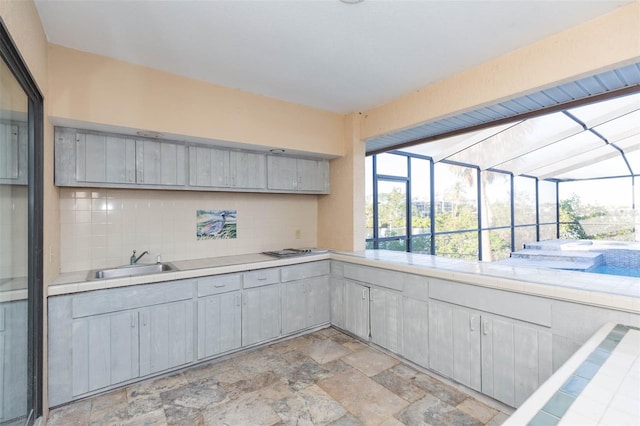 kitchen featuring tile countertops, white gas stovetop, sink, gray cabinets, and tasteful backsplash