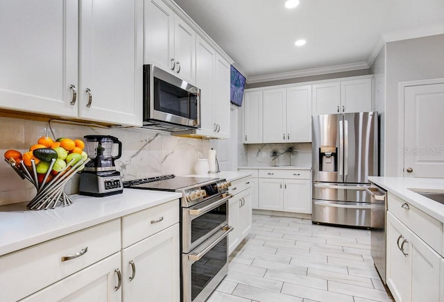 kitchen featuring tasteful backsplash, white cabinetry, stainless steel appliances, and ornamental molding