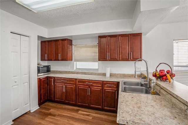 kitchen with dark hardwood / wood-style floors, sink, and a textured ceiling