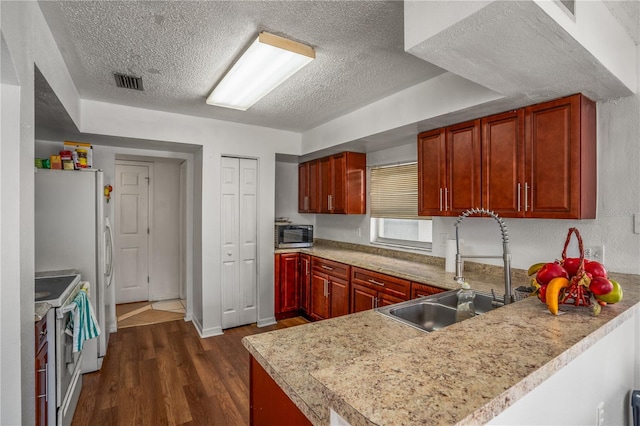 kitchen with sink, white electric range, dark hardwood / wood-style floors, a textured ceiling, and kitchen peninsula