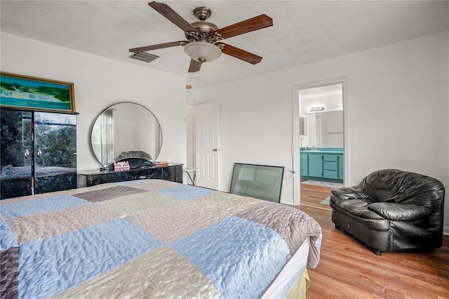 bedroom featuring ensuite bathroom, sink, a textured ceiling, hardwood / wood-style flooring, and ceiling fan