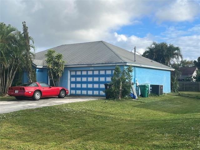 view of front facade with a garage, central air condition unit, and a front yard