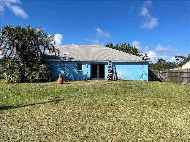 back of property featuring french doors and a lawn