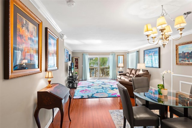 interior space featuring hardwood / wood-style flooring, an inviting chandelier, and crown molding