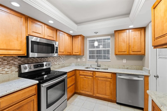 kitchen with sink, hanging light fixtures, stainless steel appliances, crown molding, and a tray ceiling