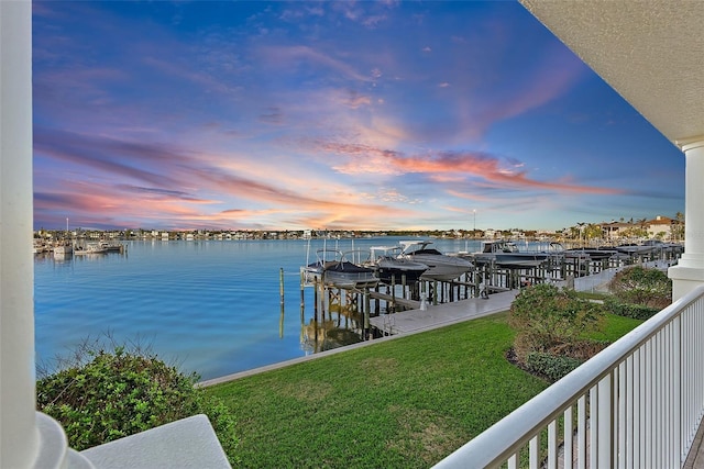 view of dock featuring a lawn and a water view