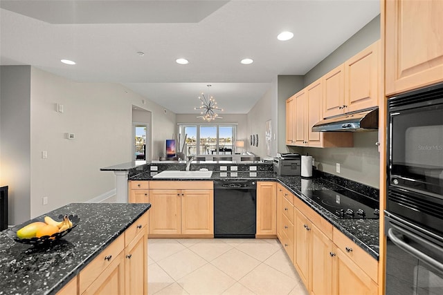 kitchen featuring dark stone counters, black appliances, sink, light brown cabinetry, and a chandelier