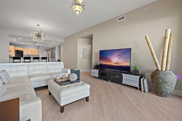 living room featuring a chandelier and light wood-type flooring