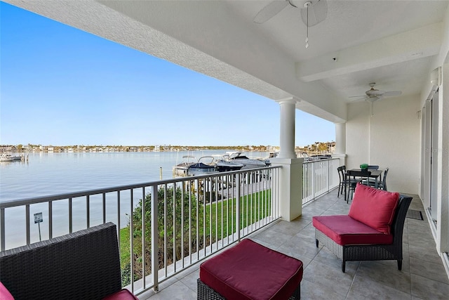 balcony with a water view and ceiling fan